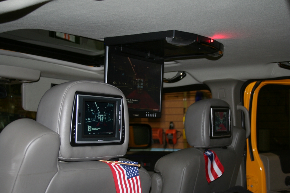Video players installed in the headrests and the ceiling of a car