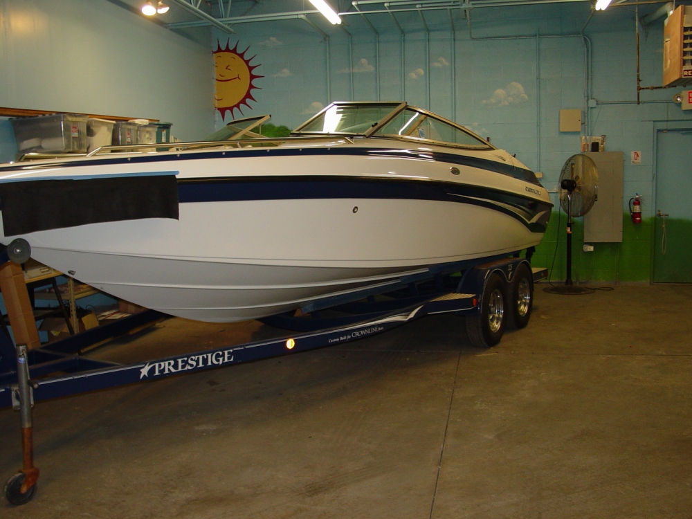 A white and navy blue ski boat in a garage