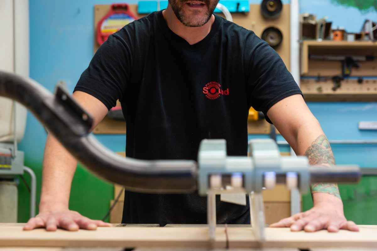 Technician cutting wood on a bandsaw