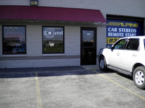 White car parked in front of Premium Sound and Security store
