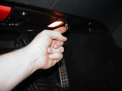 Hand pointing out custom speaker system in car